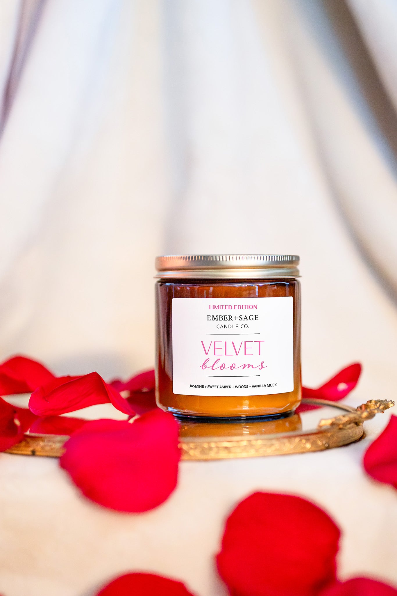 Velvet Blooms hand-poured Valentine's Day Valentine Nebraska candle in amber glass jar with rose petals. Jasmine, sweet amber, woods, vanilla musk scent.